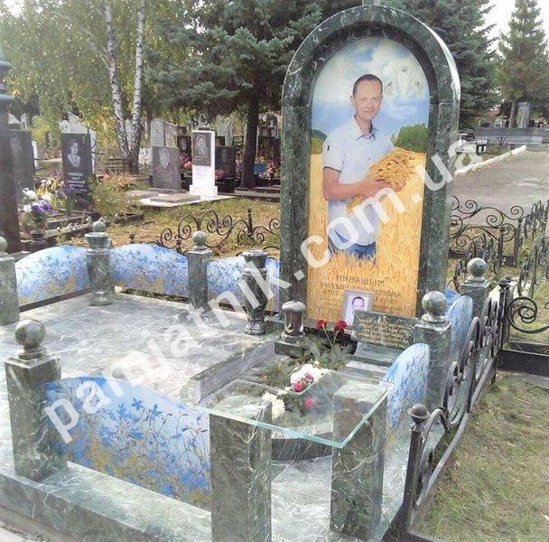 Пам'ятник в арочному обрамленні з огорожею зі скла та каменю